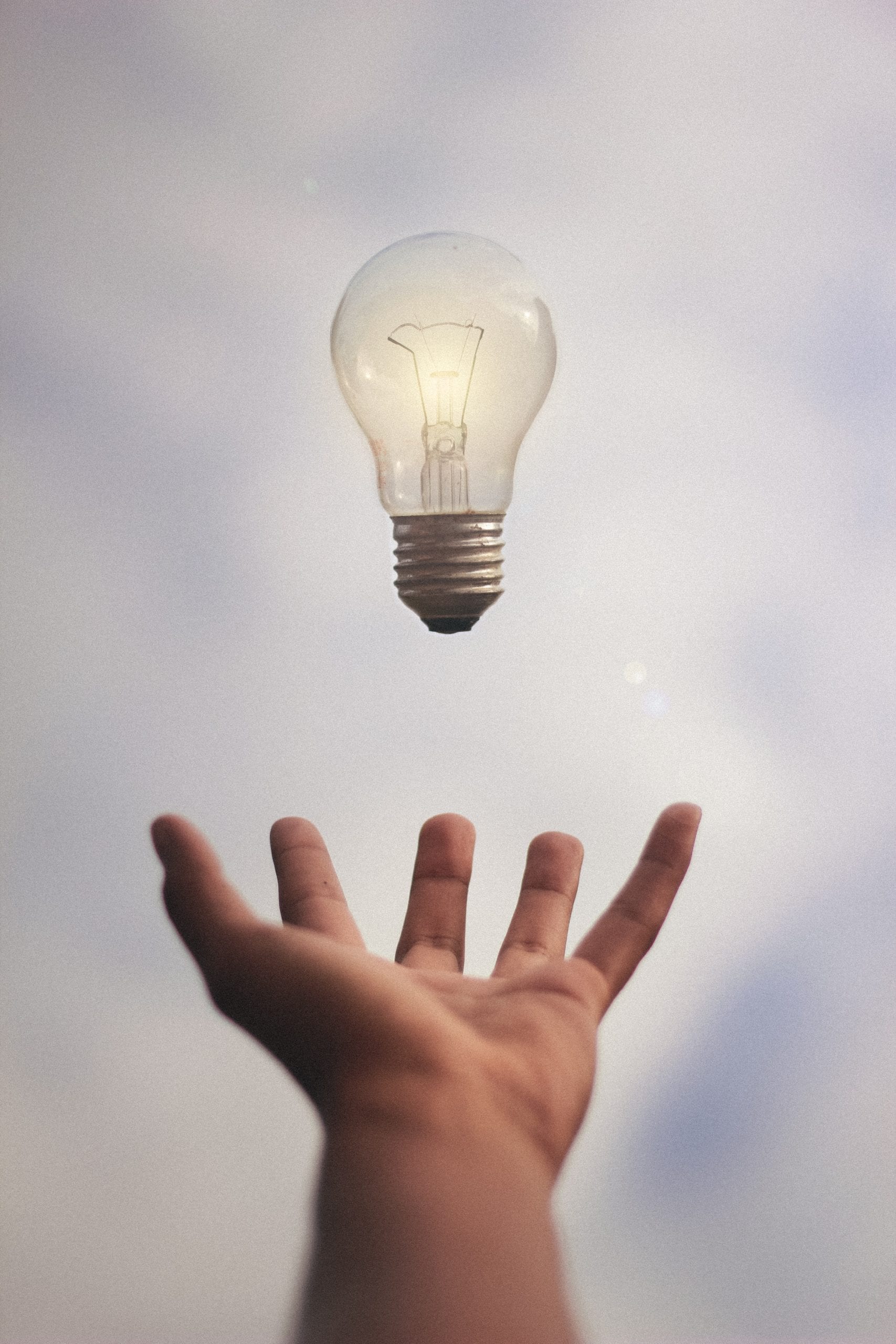 Bright lightbulb and a hand